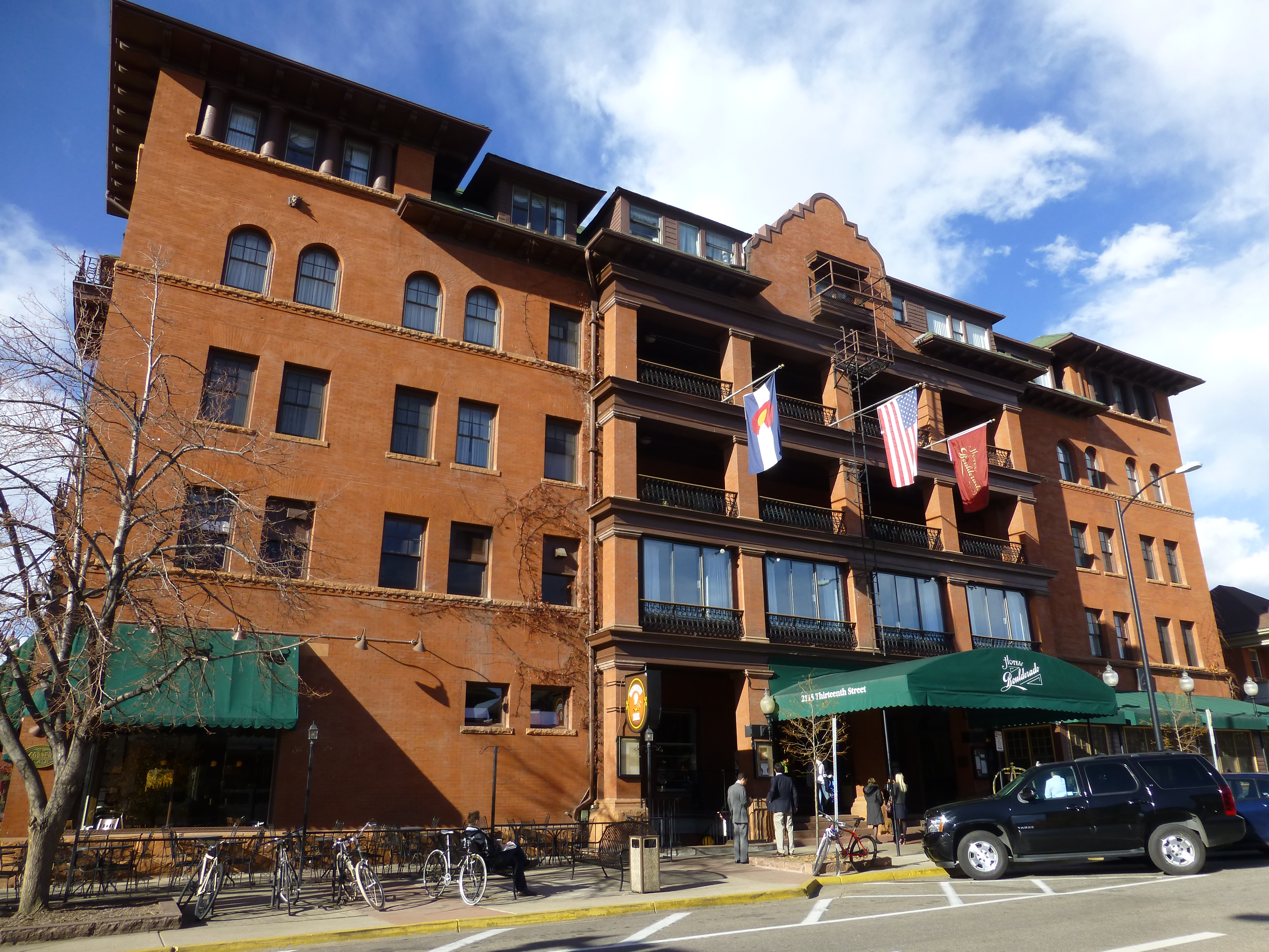 Hotel Boulderado brick exterior with balconies and its green entrance awning in Boulder, Colorado.