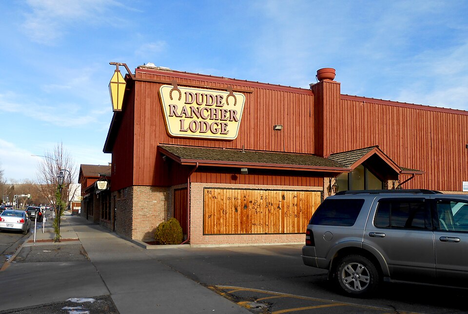 Dude Rancher Lodge exterior in Billings, Montana, with its readable lodge sign and a vehicle at the street edge.