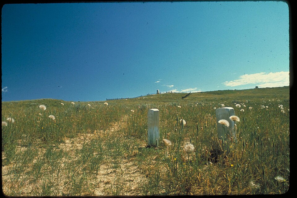 Archival National Park Service view of grave markers on the grassy slope at Little Bighorn Battlefield, Montana.